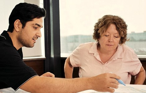 two people sitting at a table looking over paperwork